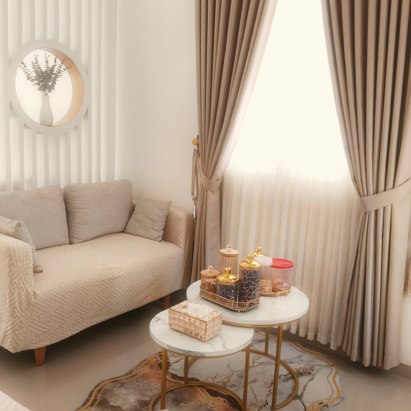 Living room with beige sofa, marble coffee table, and decorative items.